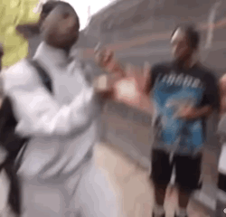 A Group Of Men Are Standing Next To Each Other On A Sidewalk And Talking To Each Other . GIF