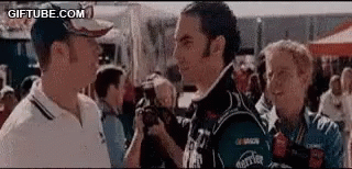 A Group Of Men Are Standing Next To Each Other Talking To Each Other . GIF
