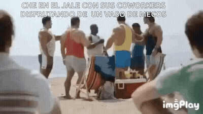 A Group Of Men Are Standing On A Beach And Talking To Each Other . GIF