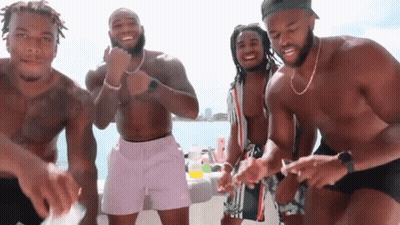 A Group Of Men Are Standing On A Boat Without Shirts On GIF