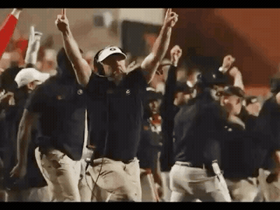 A Group Of Men Are Standing On A Football Field With Their Hands In The Air . GIF
