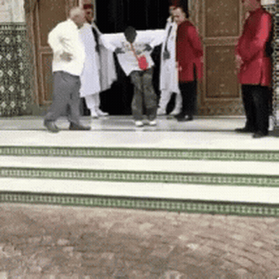A Group Of Men Are Standing On A Set Of Stairs In Front Of A Building GIF