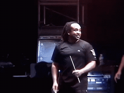 A Group Of Men Are Standing On A Stage And One Of Them Is Wearing A Mask . GIF