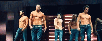 A Group Of Men Are Standing On A Stage Without Shirts On . GIF