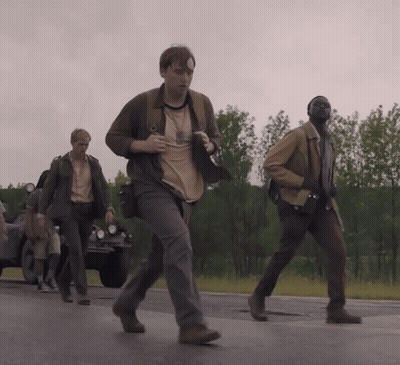 A Group Of Men Are Walking Down A Road And One Of Them Is Wearing A Shirt That Says ' A ' GIF