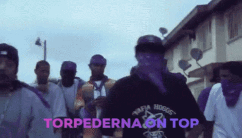 A Group Of Men Are Walking Down A Street And The Words Torpedona On Top Are On The Screen GIF