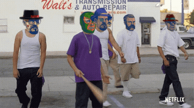 A Group Of Men Are Walking Down The Street In Front Of A Walt 'S Transmission And Auto Repair Store GIF