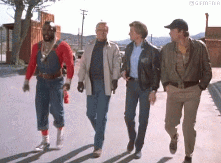 A Group Of Men Are Walking Down The Street . GIF