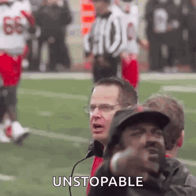A Group Of Men Are Watching A Football Game And One Of Them Is Wearing A Hat And Glasses . GIF