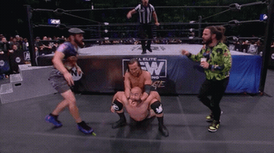 A Group Of Men Are Wrestling In A Ring With A Sign That Says Elite Wrestling GIF
