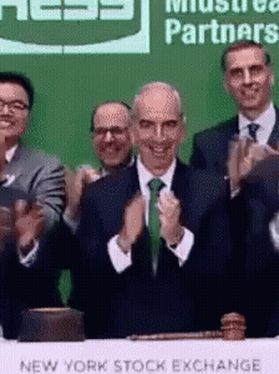 A Group Of Men Clapping In Front Of A New York Stock Exchange Table GIF