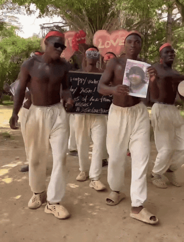 A Group Of Men Holding A Sign That Says Happy Vader GIF