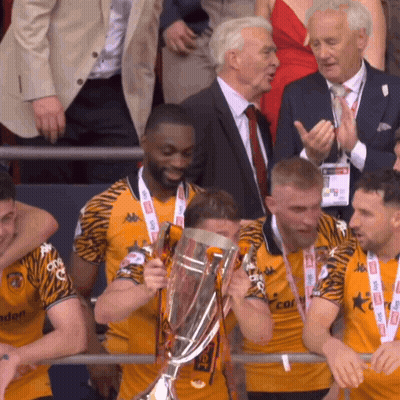 A Group Of Men Holding A Trophy With One Wearing A Shirt That Says ' Tigers ' On It GIF