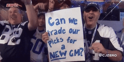 A Group Of Men Holding Up A Sign That Says " Can We Trade Our Picks For A New Gm " GIF