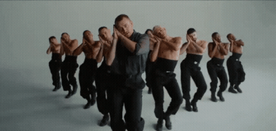 A Group Of Men In Black Pants Are Dancing In A Row . GIF