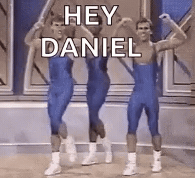 A Group Of Men In Blue Leotards Are Dancing On A Stage And Saying `` Hey Daniel '' . GIF