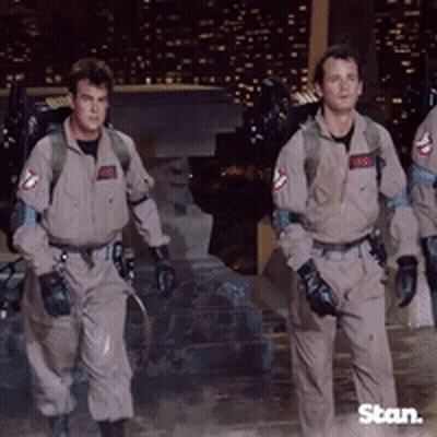 A Group Of Men In Ghostbusters Uniforms Walking GIF