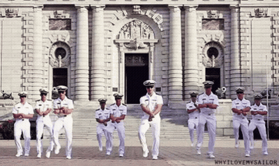 A Group Of Men In Military Uniforms Are Dancing In Front Of A Building That Says Why I Love My Sailor GIF