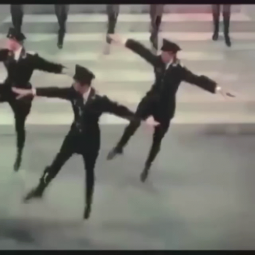 A Group Of Men In Military Uniforms Are Dancing Together On A Street . GIF
