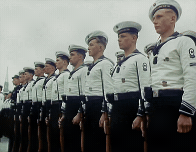 A Group Of Men In Military Uniforms Are Standing In A Row GIF