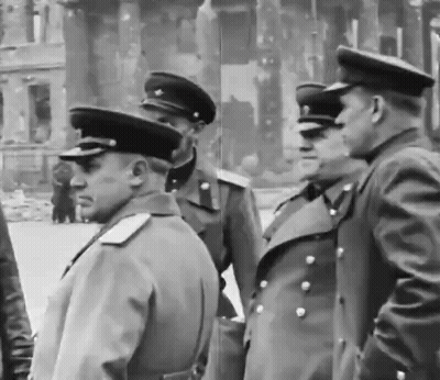 A Group Of Men In Military Uniforms Are Standing In Front Of A Building GIF