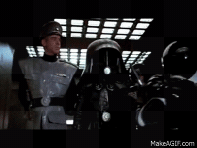 A Group Of Men In Military Uniforms Are Standing Next To Each Other In A Dark Room . GIF