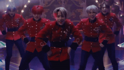 A Group Of Men In Red Uniforms Are Dancing Together GIF