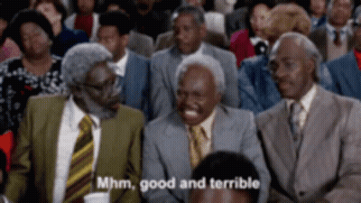 A Group Of Men In Suits And Ties Are Sitting In A Crowd And One Of Them Is Laughing And Saying Mhm Good And Terrible GIF