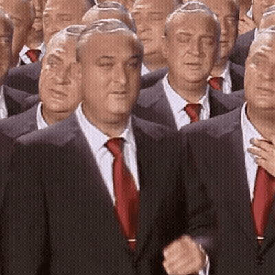 A Group Of Men In Suits And Ties Are Standing In A Row . GIF