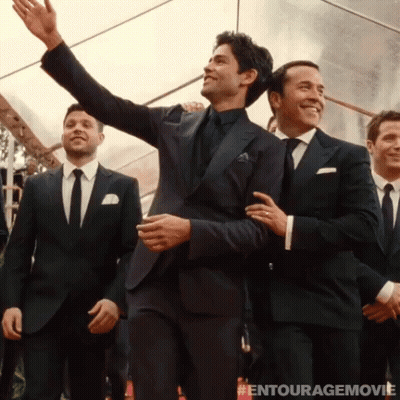 A Group Of Men In Suits And Ties Are Standing In Front Of A Tent With The Entourage Movie Written On The Bottom GIF