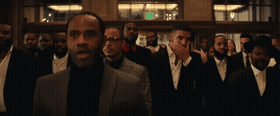 A Group Of Men In Suits And Ties Are Standing Next To Each Other . GIF
