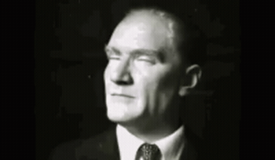 A Group Of Men In Suits And Ties Are Standing Next To Each Other In A Room . GIF