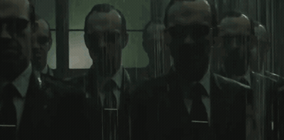 A Group Of Men In Suits And Ties Are Standing Next To Each Other In A Room . GIF