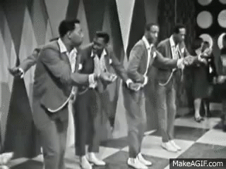 A Group Of Men In Suits Are Dancing On A Stage . GIF