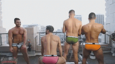 A Group Of Men In Underwear Are Dancing On A Rooftop GIF