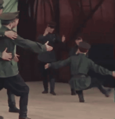 A Group Of Men In Uniforms Are Dancing On A Stage GIF