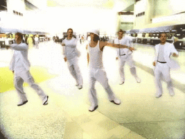 A Group Of Men In White Clothes Are Dancing In A Room GIF