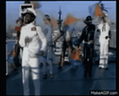 A Group Of Men In White Military Uniforms Are Standing On A Boat . GIF