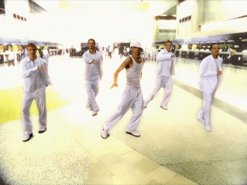 A Group Of Men In White Suits Are Dancing GIF