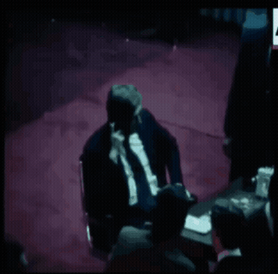 A Group Of Men Sitting Around A Table With A Chess Board On It GIF