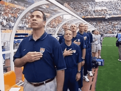 A Group Of Men Stand With Their Hands On Their Hearts GIF