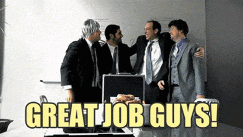 A Group Of Men Standing Around A Briefcase That Says " Great Job Guys " On It GIF