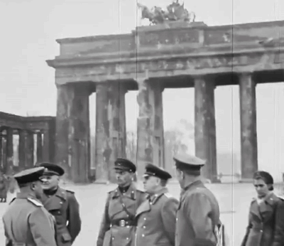 A Group Of Men Standing In Front Of A Building With Columns GIF