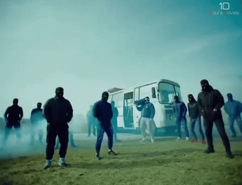 A Group Of Men Standing In Front Of A Bus With The Number 10 On The Bottom Right GIF