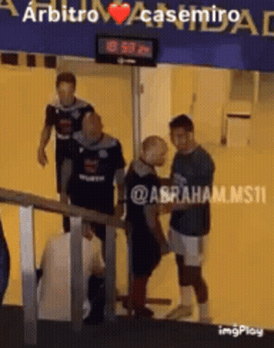 A Group Of Men Standing In Front Of A Sign That Says Arbitro GIF