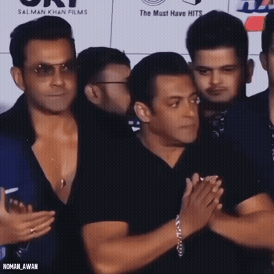 A Group Of Men Standing In Front Of A Sign That Says ' Salman Khan Films ' GIF
