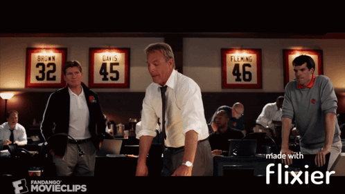 A Group Of Men Standing In Front Of A Wall With Jerseys On It That Say Brown Davis And Flaming GIF