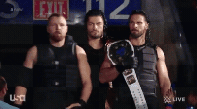 A Group Of Men Standing Next To Each Other Holding A Wrestling Championship Belt . GIF
