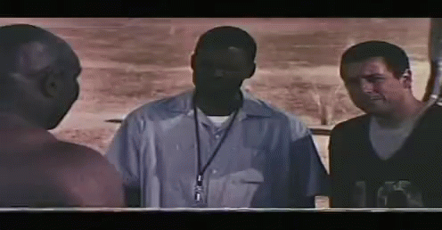 A Group Of Men Standing Next To Each Other In A Dark Room . GIF