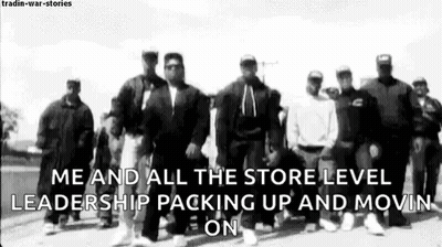 A Group Of Men Standing Next To Each Other On A Street . GIF